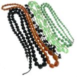 A faceted vulcanite bead necklace, together with three further plastic and glass bead examples.