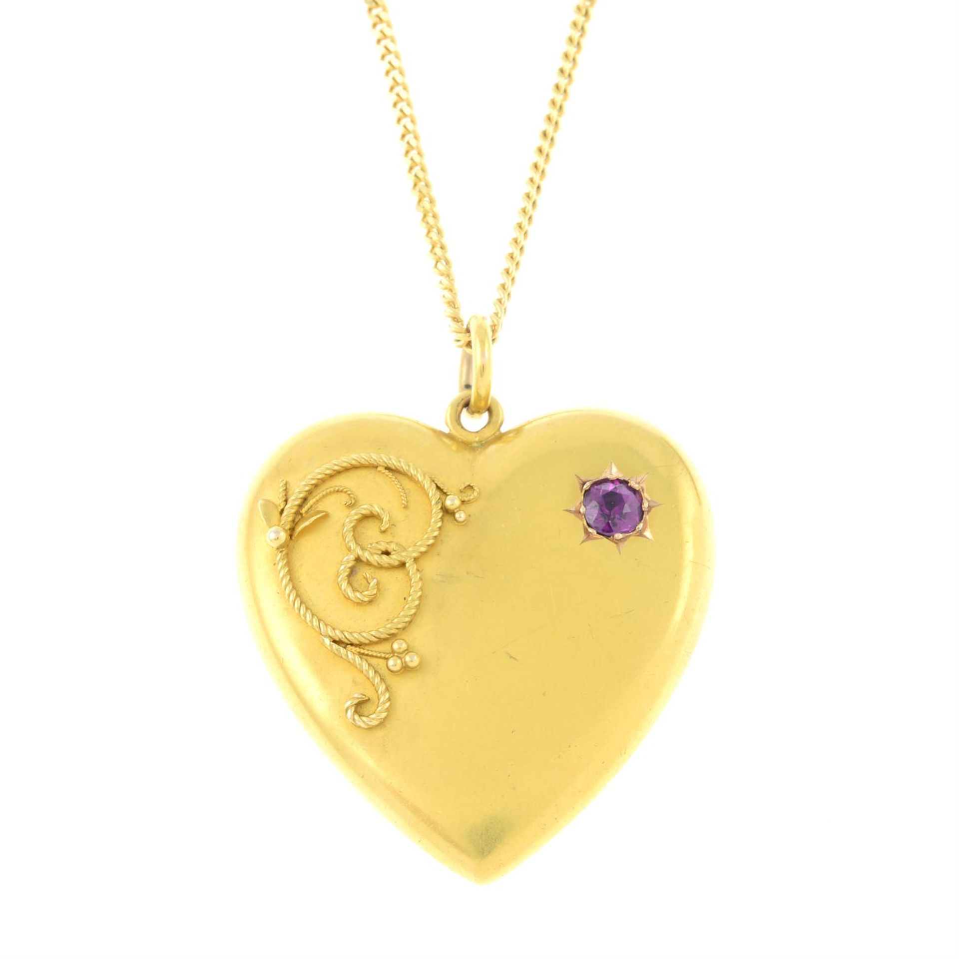 An early 20th century 15ct gold garnet heart-shape pendant, suspended from a later 9ct gold chain.