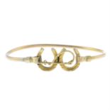 An early 20th century 9ct gold double horseshoe and riding crop bangle.
