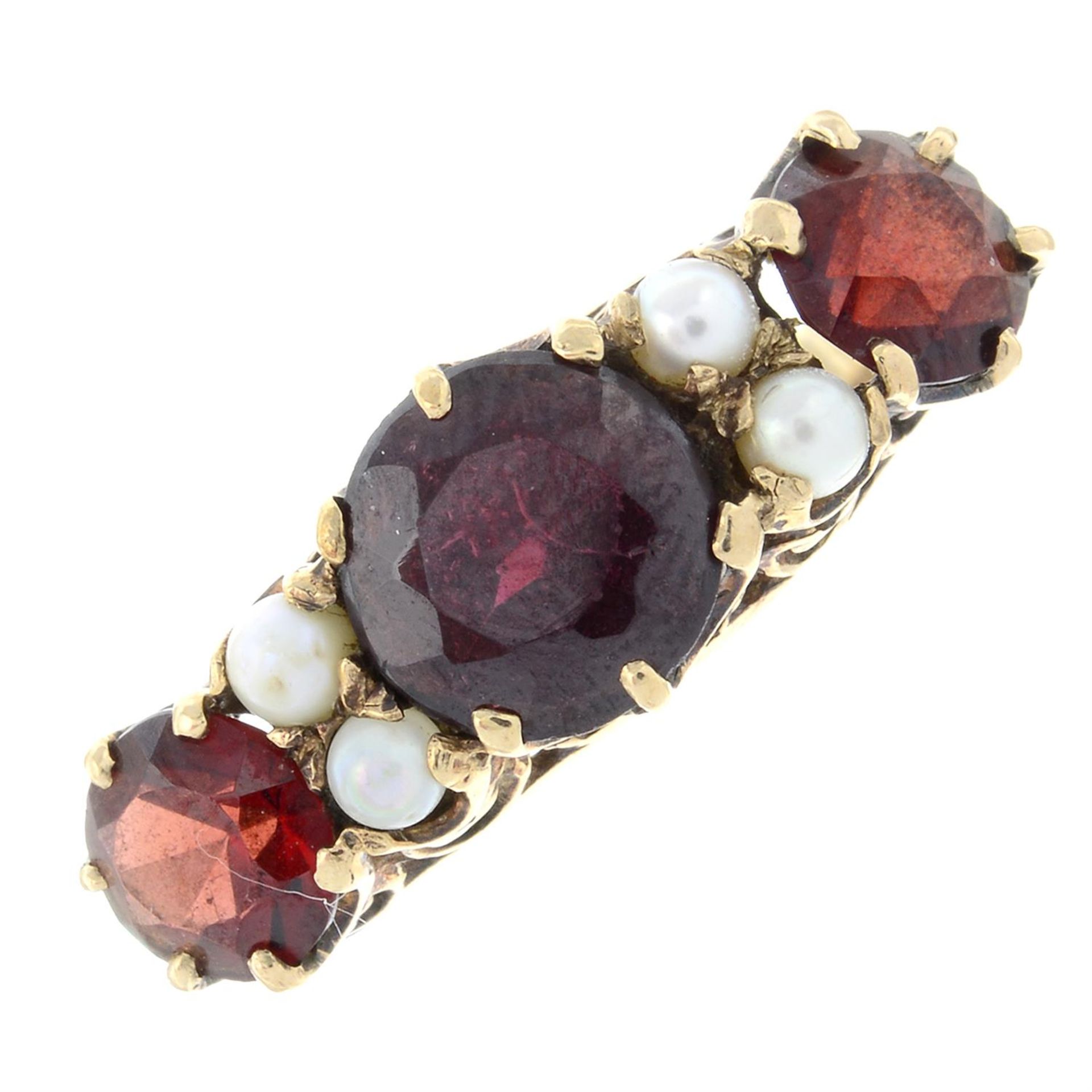 A 1960's 9ct gold garnet three-stone ring, with seed pearl spacers.