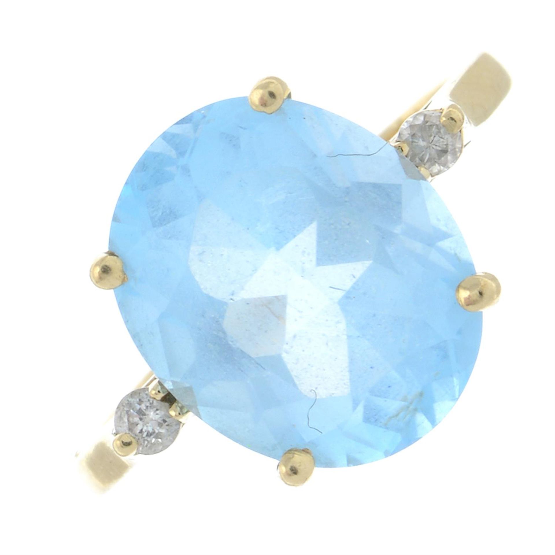 A blue topaz single-stone ring, with diamond accent shoulders.