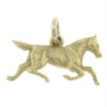 An early 20th century 9ct gold running horse pendant/charm.