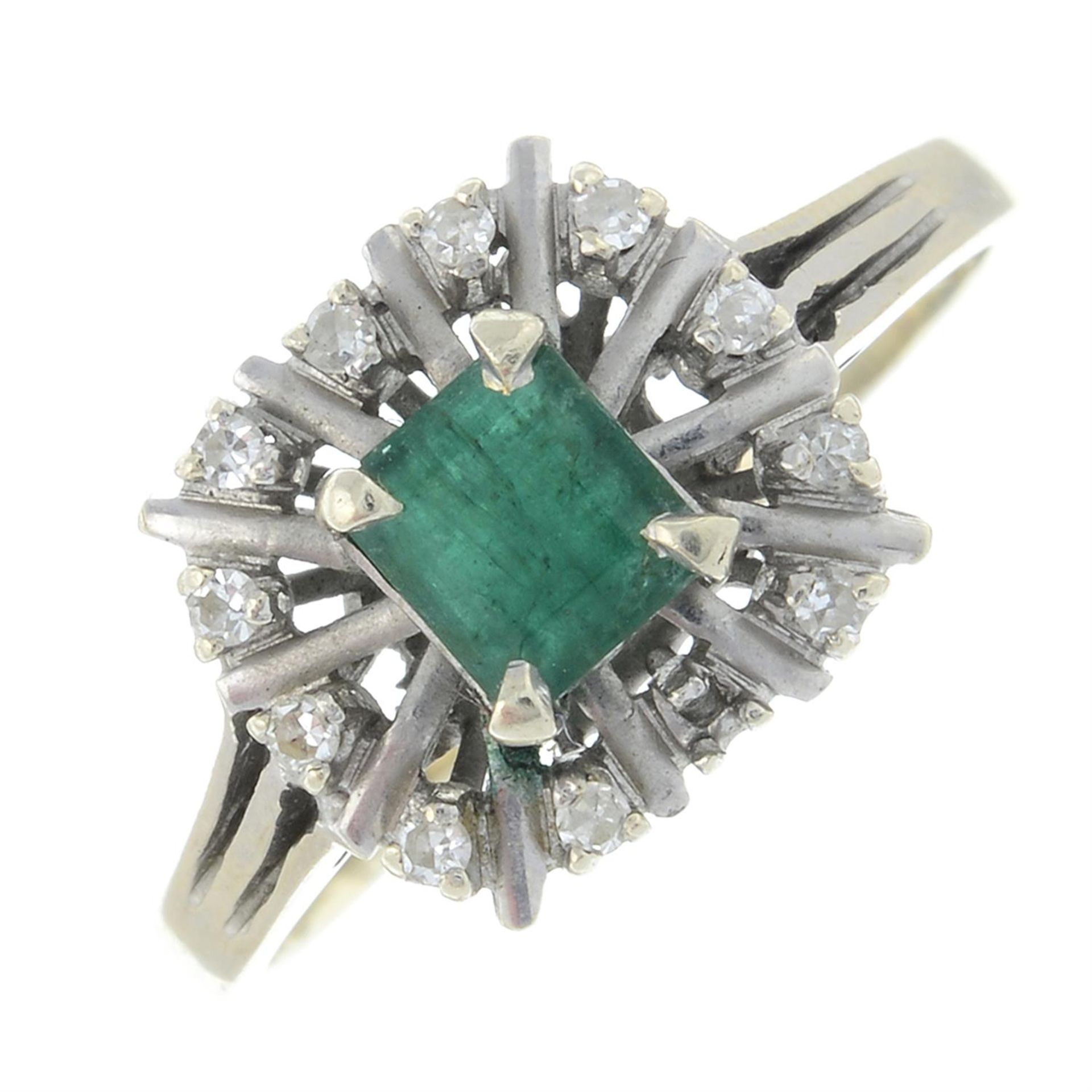 An emerald and diamond cluster ring.