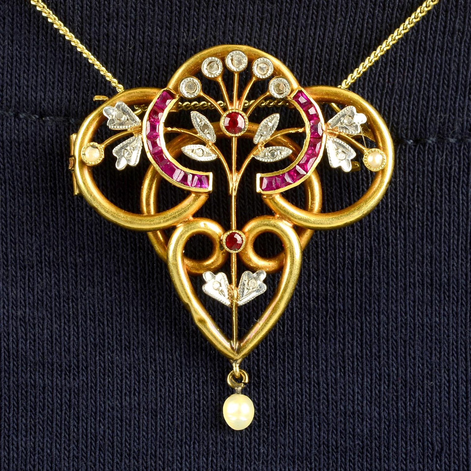 An early 20th century 18ct gold vari-cut ruby, diamond point and seed pearl pendant.