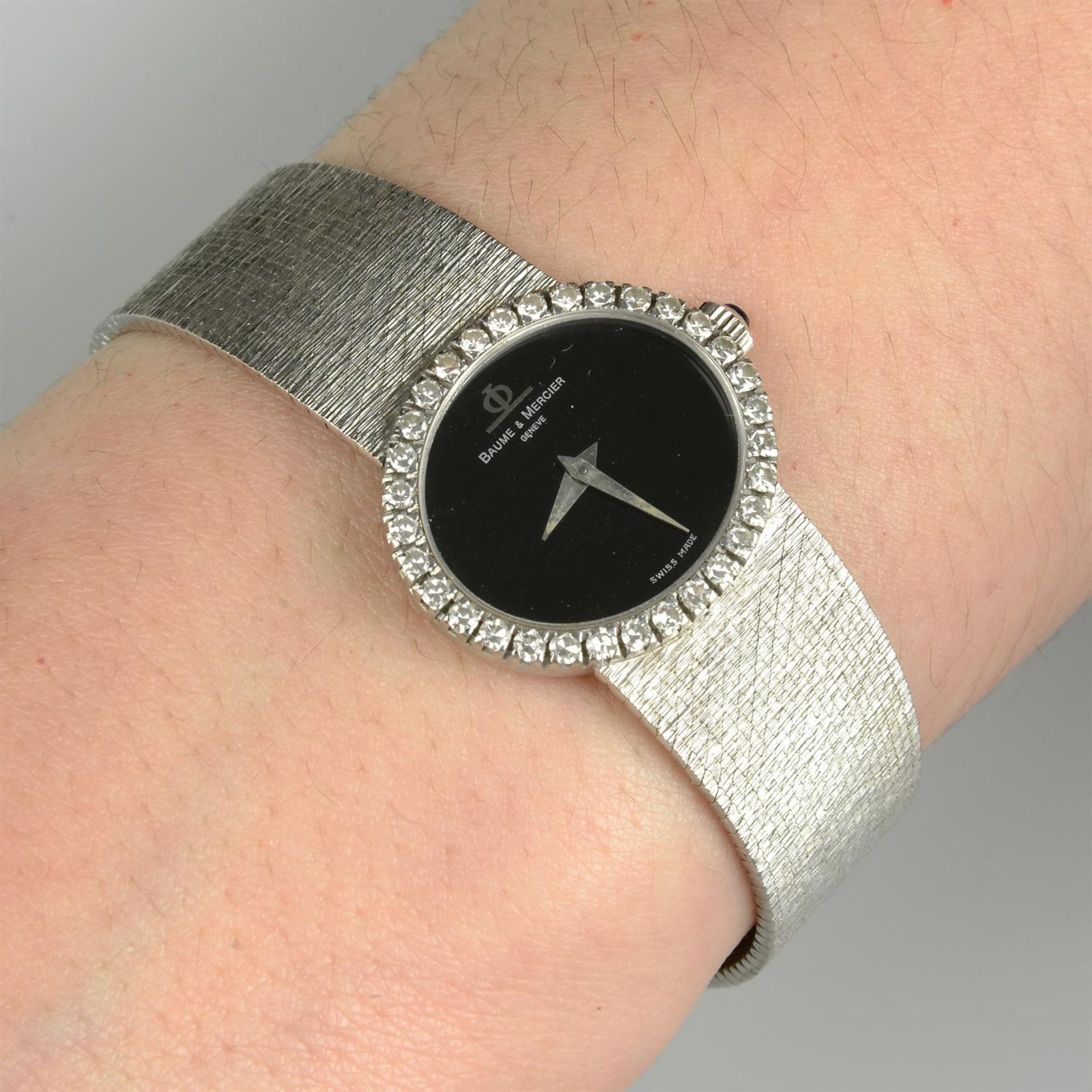 A lady's 18ct gold black dial wrist watch, with single-cut diamond bezel and integral textured