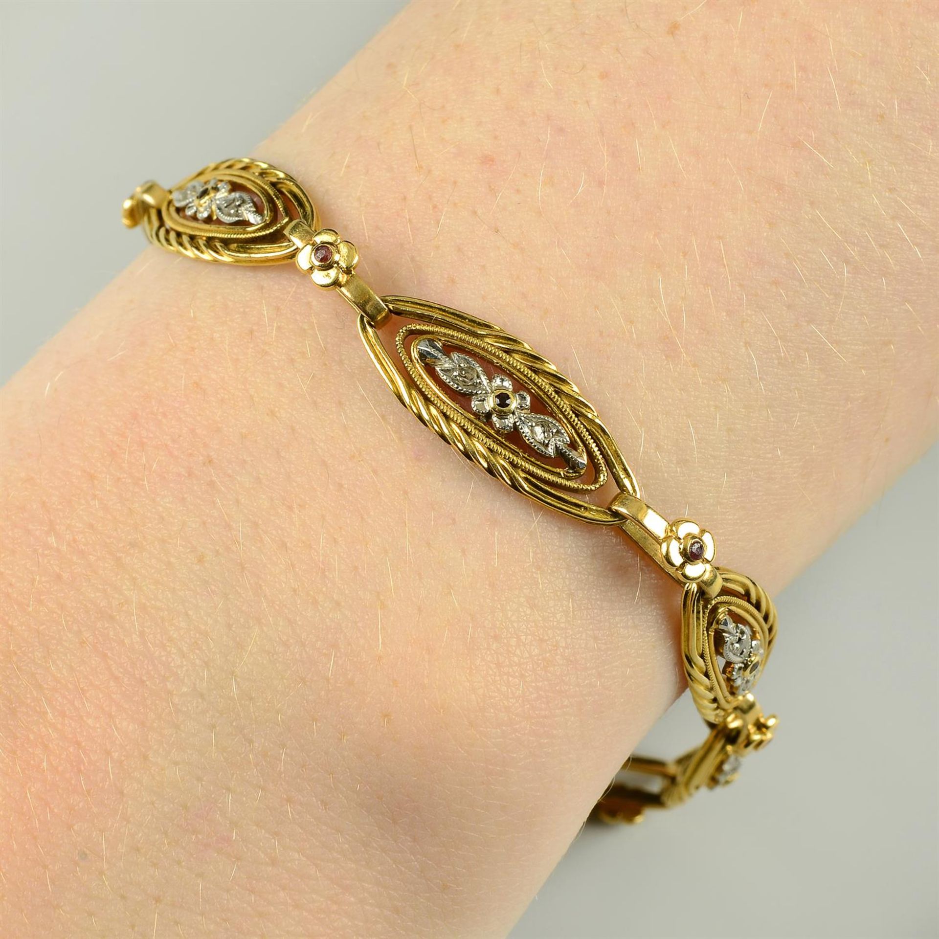 A French Art Nouveau platinum and 18ct gold, ruby and diamond point floral bracelet.