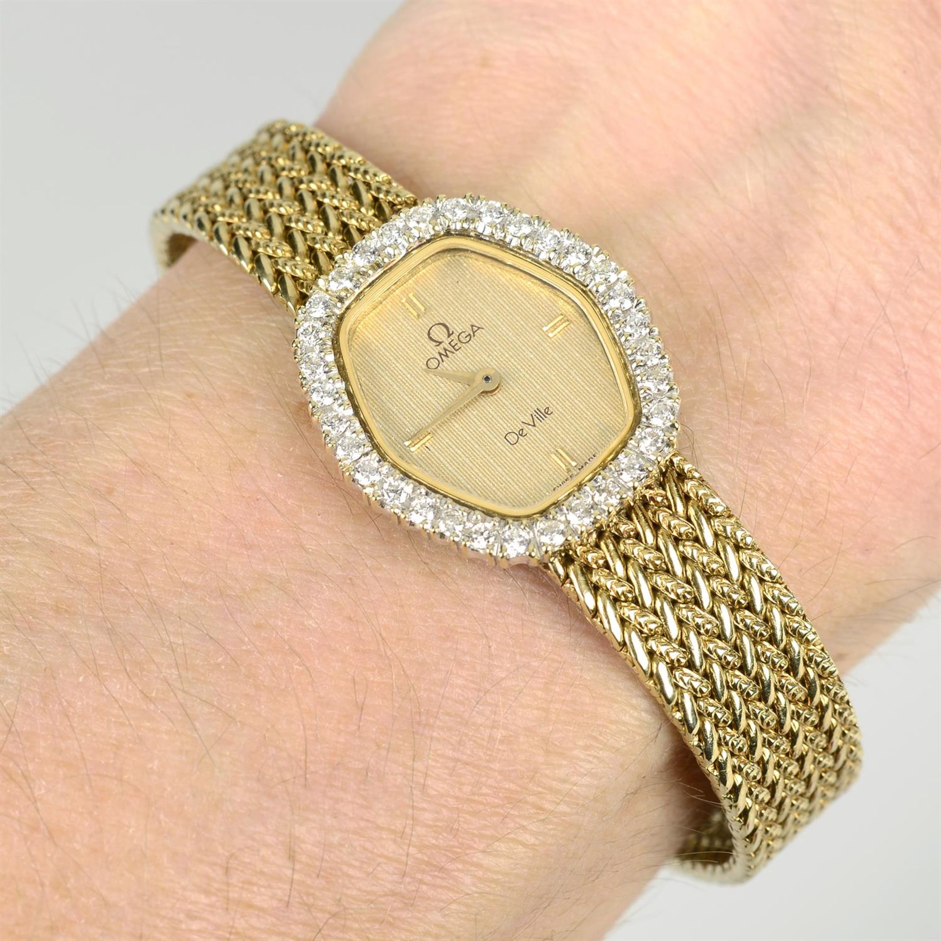A lady's wrist watch, with diamond bezel and integral bracelet, the dial signed Omega, De Ville.