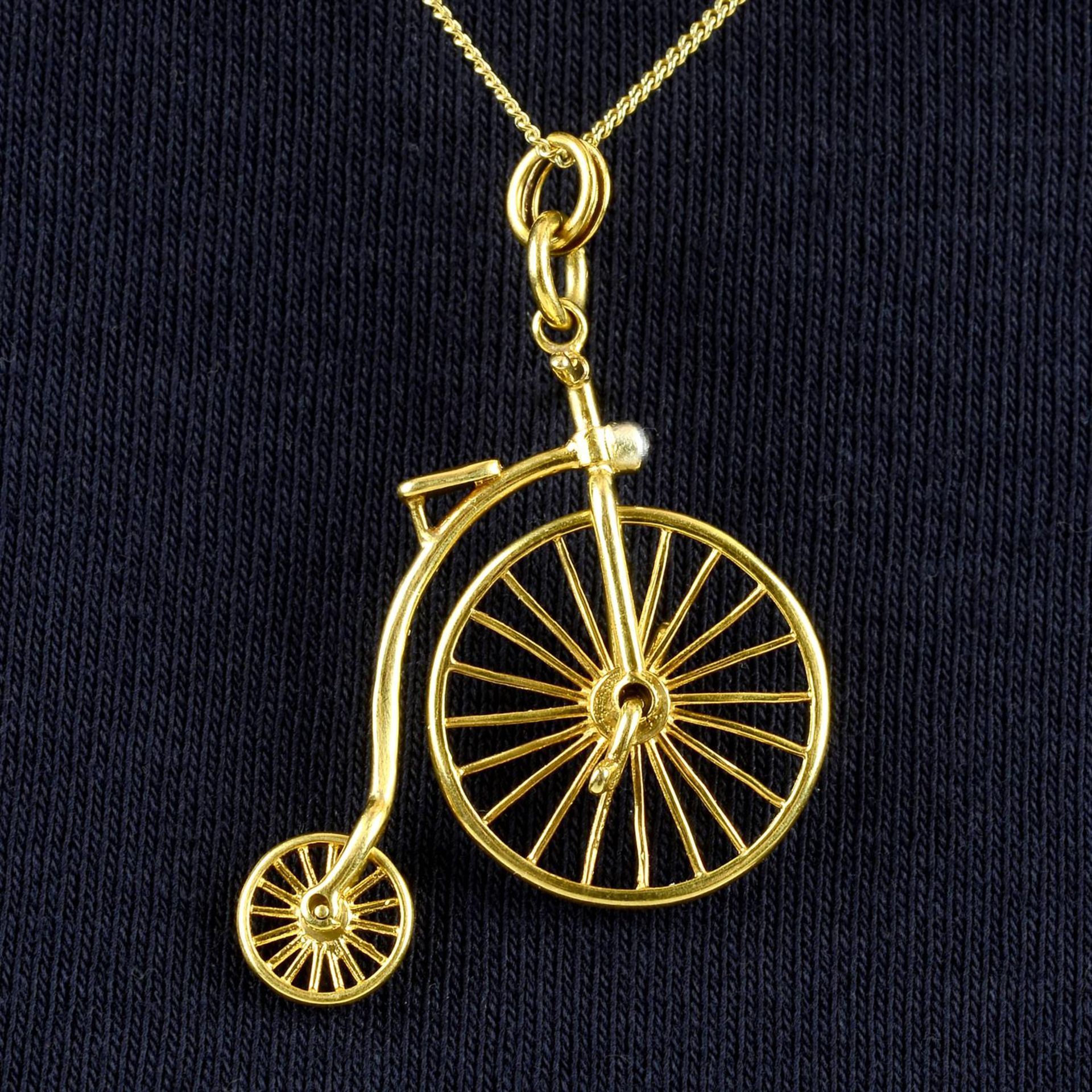 A Penny Farthing bicycle pendant, with diamond light and free moving wheels.