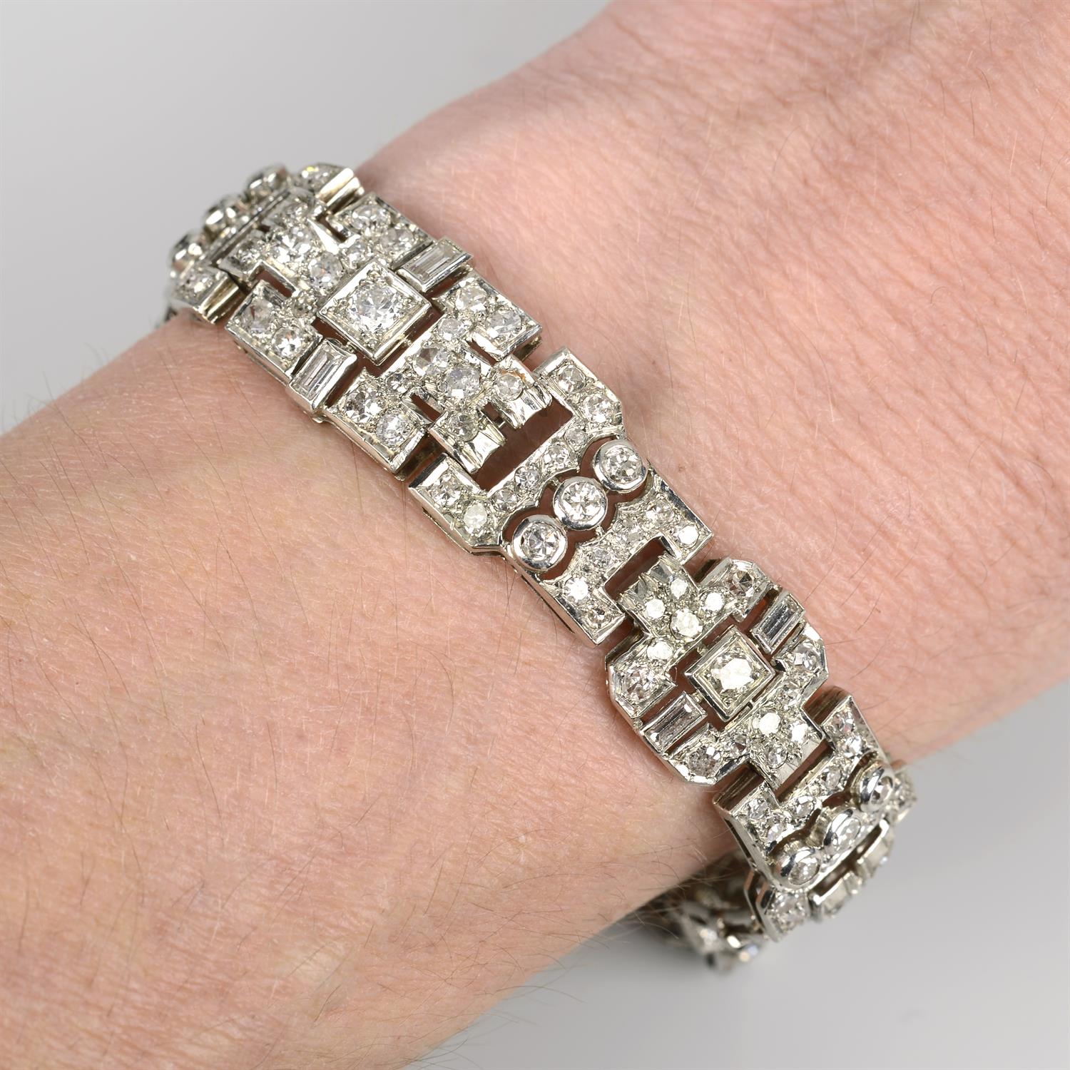 An early 20th century 18ct gold vari-cut diamond geometric panel bracelet.