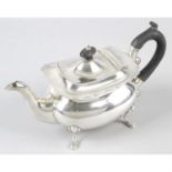 An Edwardian silver teapot of plain bellied form.