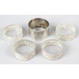 Four filigree napkin rings, together with a hallmarked silver singular example. (5).