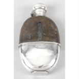 An early 20th century silver and leather mounted glass hip flask.