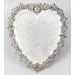 A heart shape bevelled mirror in pierced metal mount.