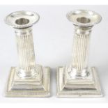 A matched pair of Edwardian silver classical column candlesticks.