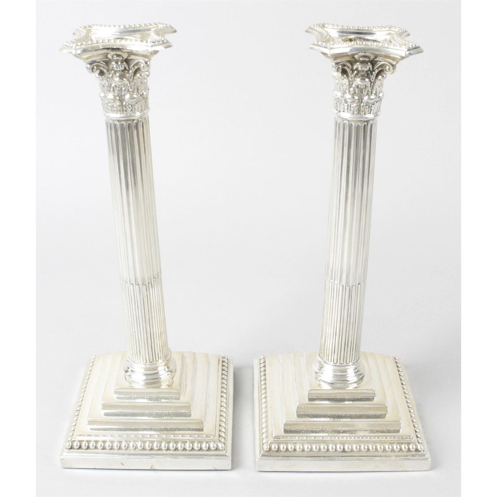 A pair of Edwardian silver Corinthian column candlesticks.