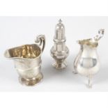 Two late Victorian silver cream jugs, together with a 1920's silver pepperette. (3).