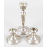 A pair of mid-20th century silver dwarf candlesticks, together with a later silver single