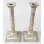 A pair of late Victorian silver Corinthian column candlesticks (filled).
