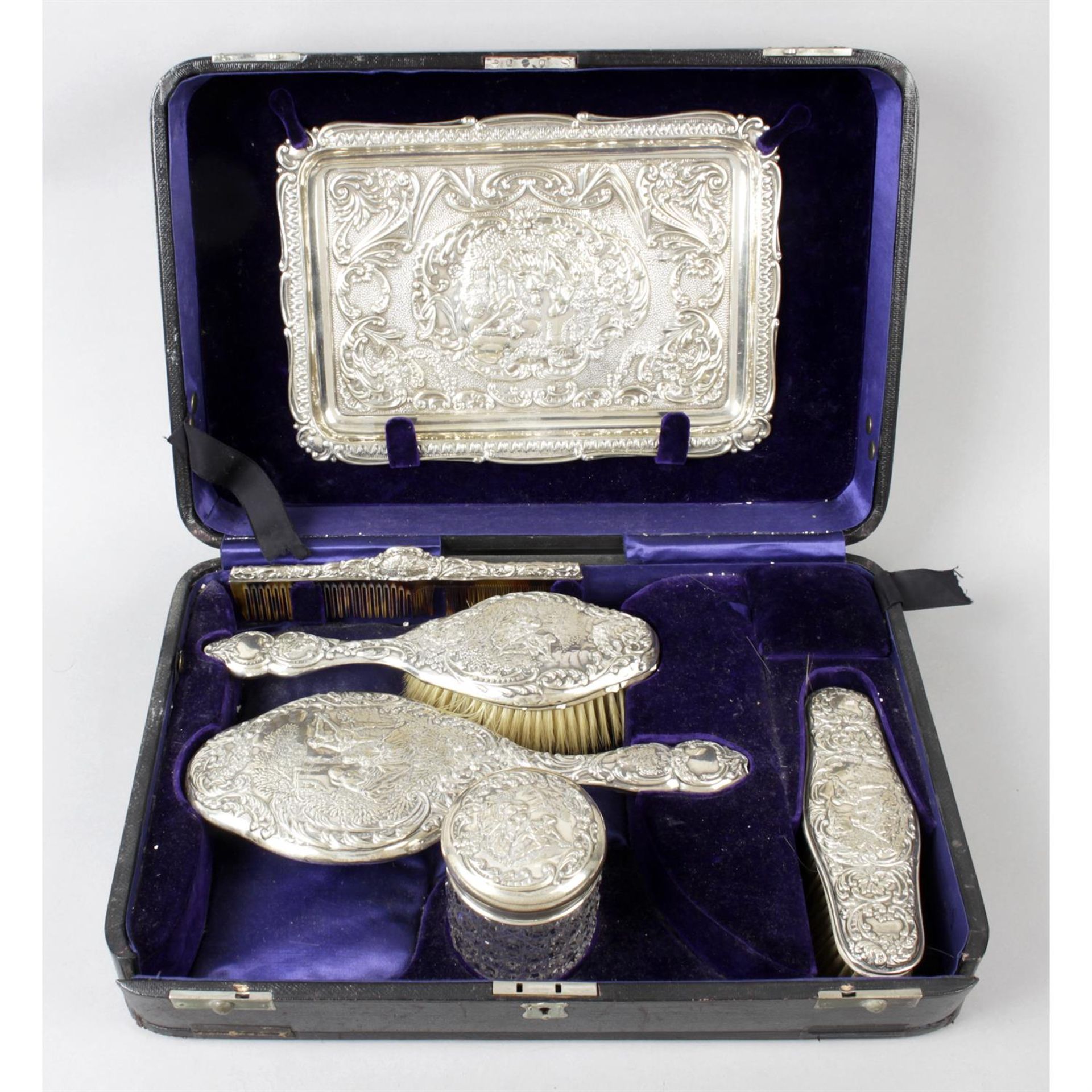 A cased Edwardian silver and silver mounted dressing table set by Walker & Hall; together with a