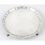 A 1920's silver salver, with gadroon rim and hoof feet.