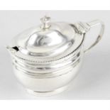 A George III silver mustard pot, with blue glass liner & a later spoon.