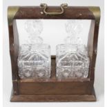 A mahogany veneer tantalus, together with a cased silver plated canteen for eight place settings,