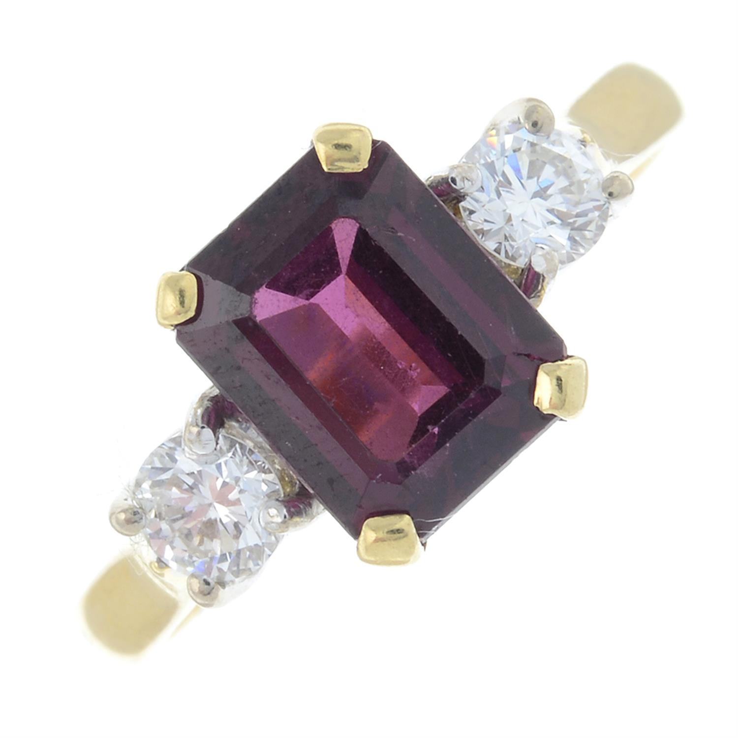 An 18ct gold garnet and brilliant-cut diamond three-stone ring.