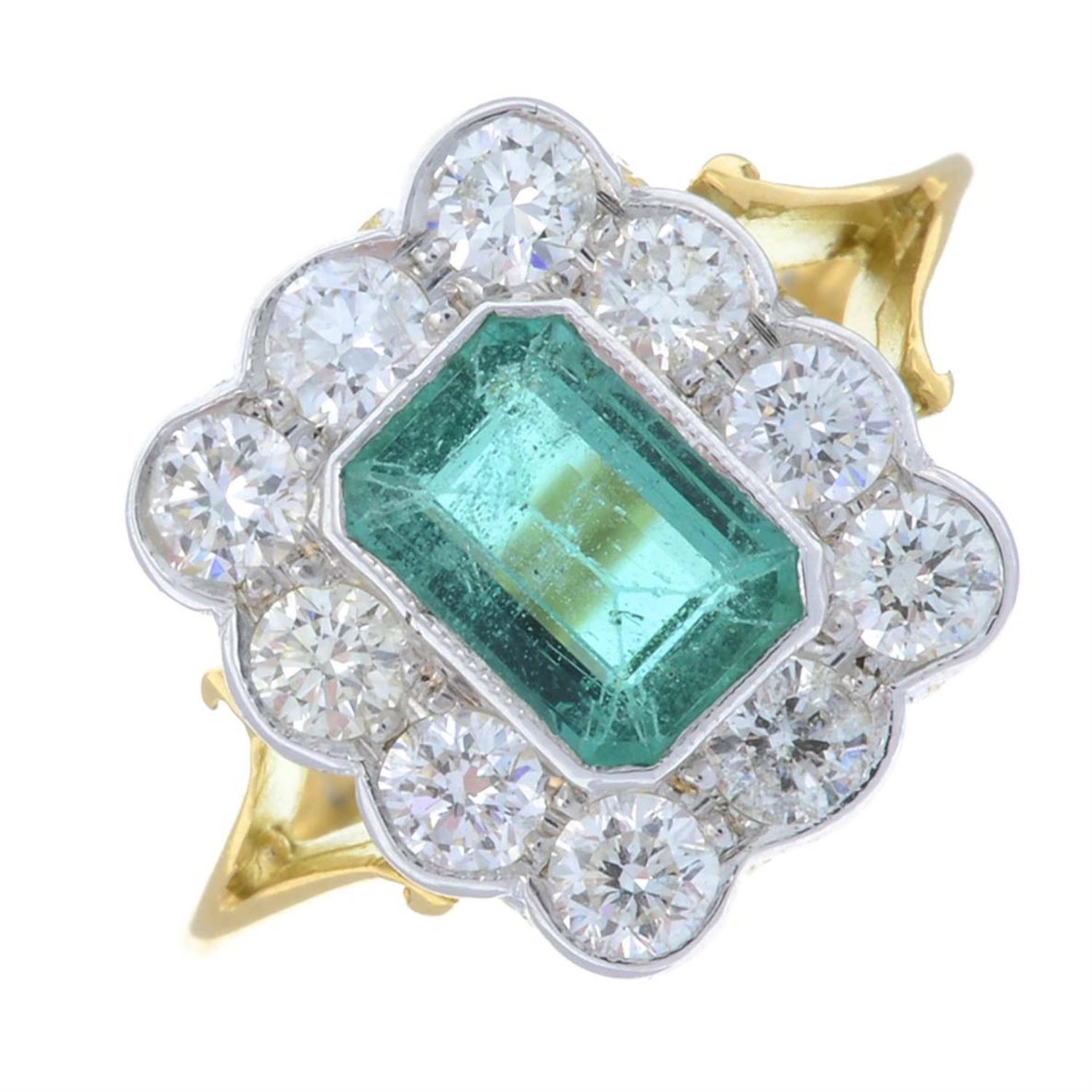 An emerald and diamond cluster ring.