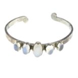 A cuff bangle, set with five graduated moonstone cabochons.