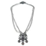 An early 20th century silver garnet floral filigree necklace.