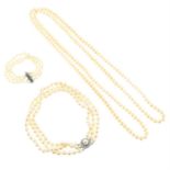 A selection of imitation pearl jewellery, comprising two necklaces and a bracelet.