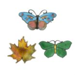 Three enamel brooches, to include two butterflies and a maple leaf.