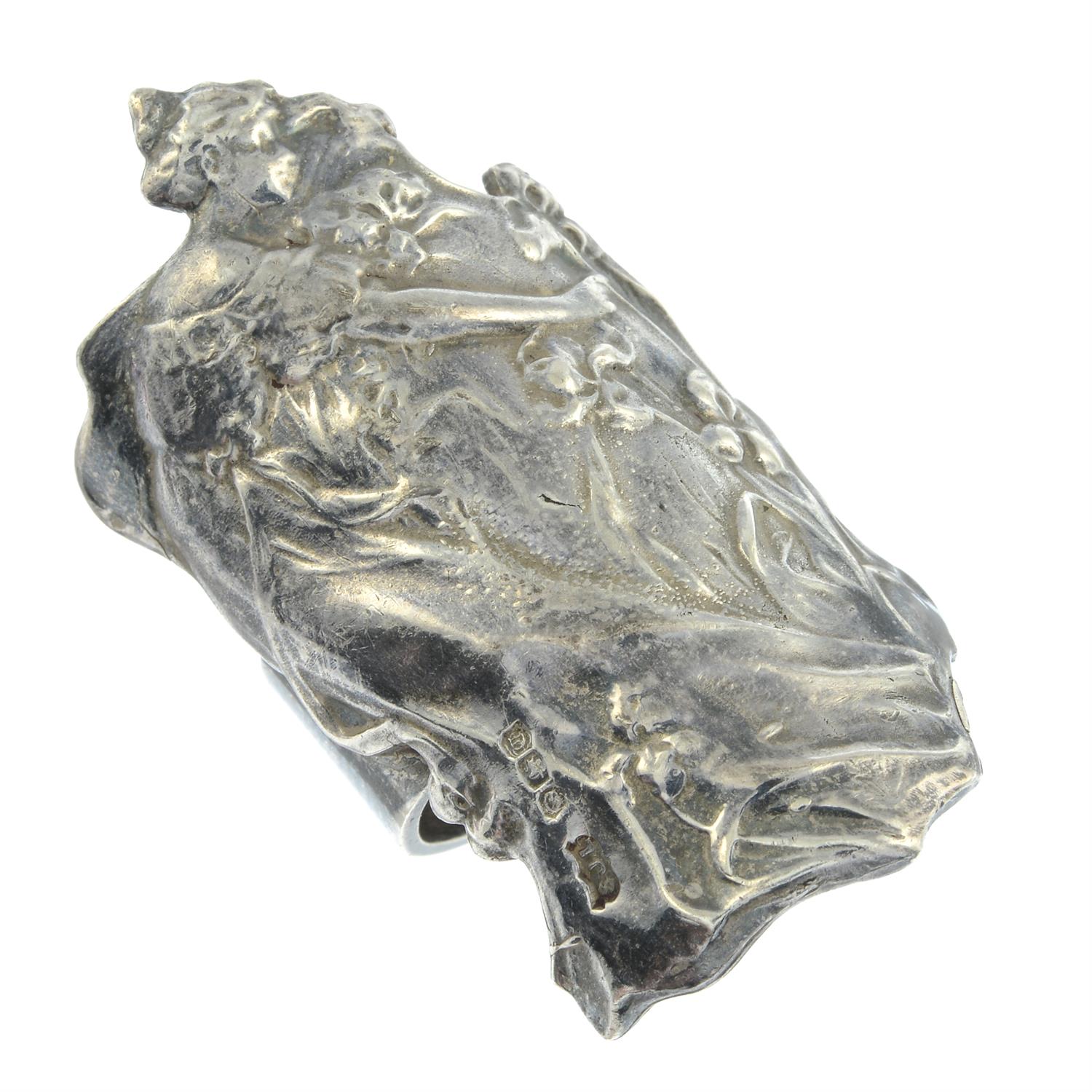 An Art Nouveau silver ring, depicting a woman with flowers.