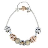 A bi-colour charm bracelet with ten charms, by Pandora.