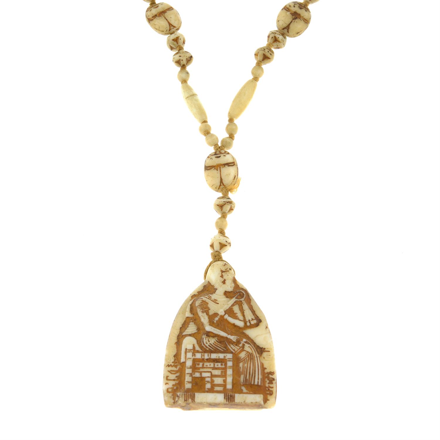 A carved bone bead necklace, with Egyptian iconography.