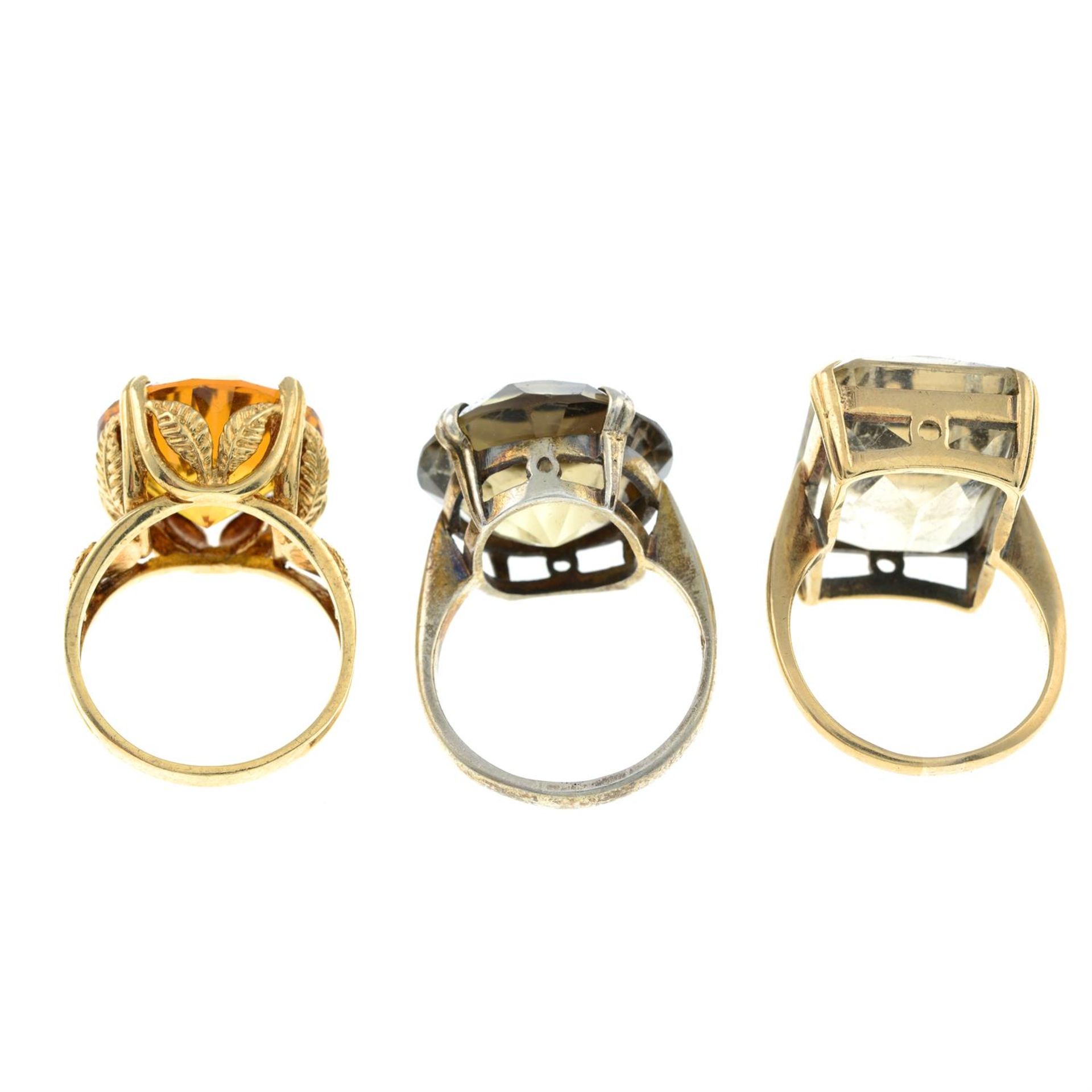 Three citrine, smokey quartz and synthetic yellow sapphire single-stone rings. - Image 2 of 2