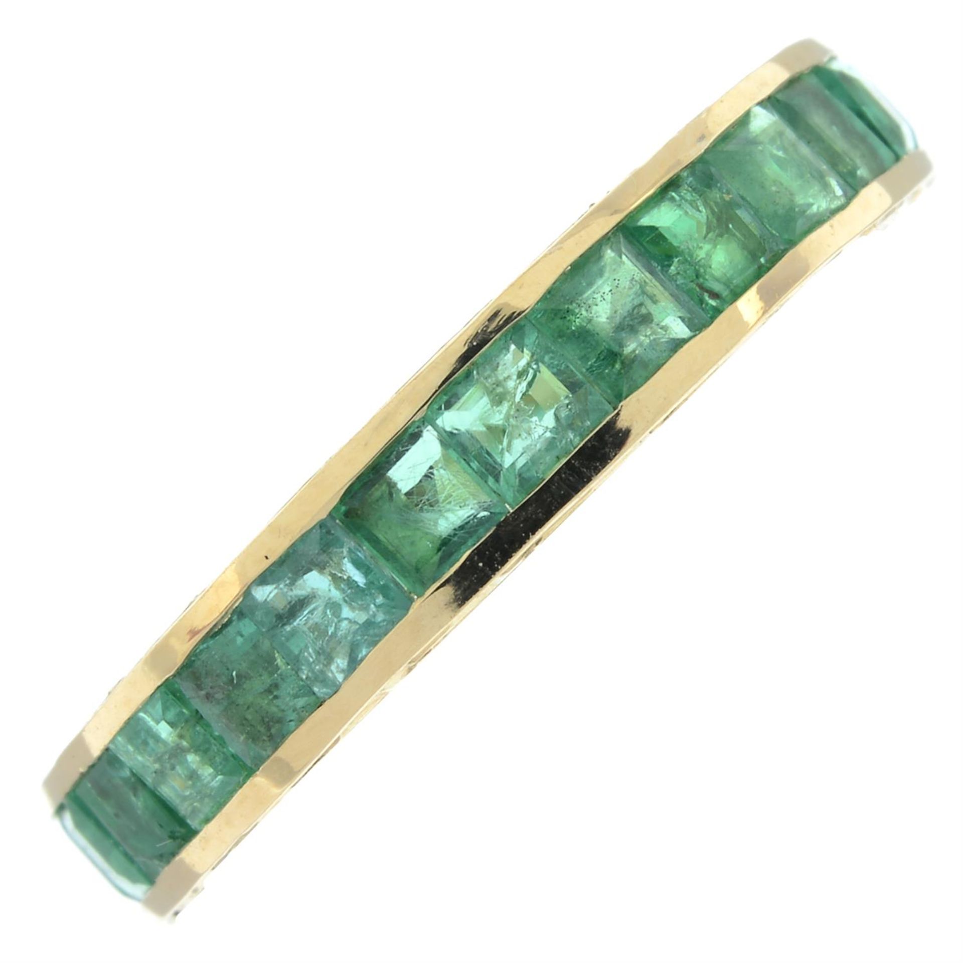 An emerald full eternity ring, with engraved sides.