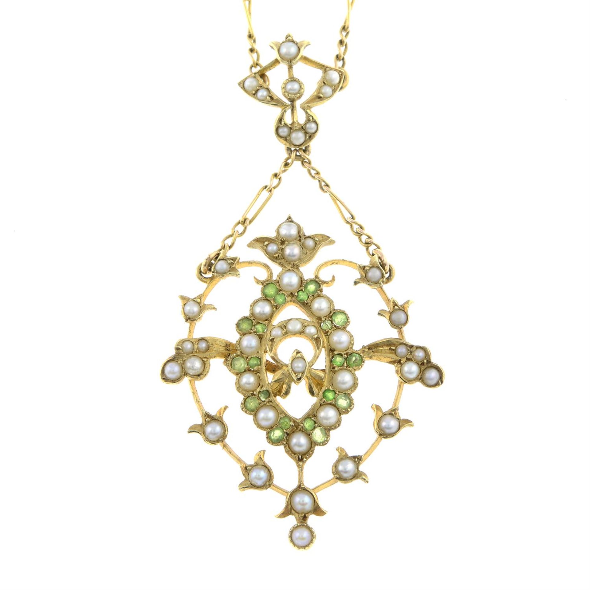 An early 20th century 15ct gold demantoid garnet and split pearl pendant, on an integral chain.