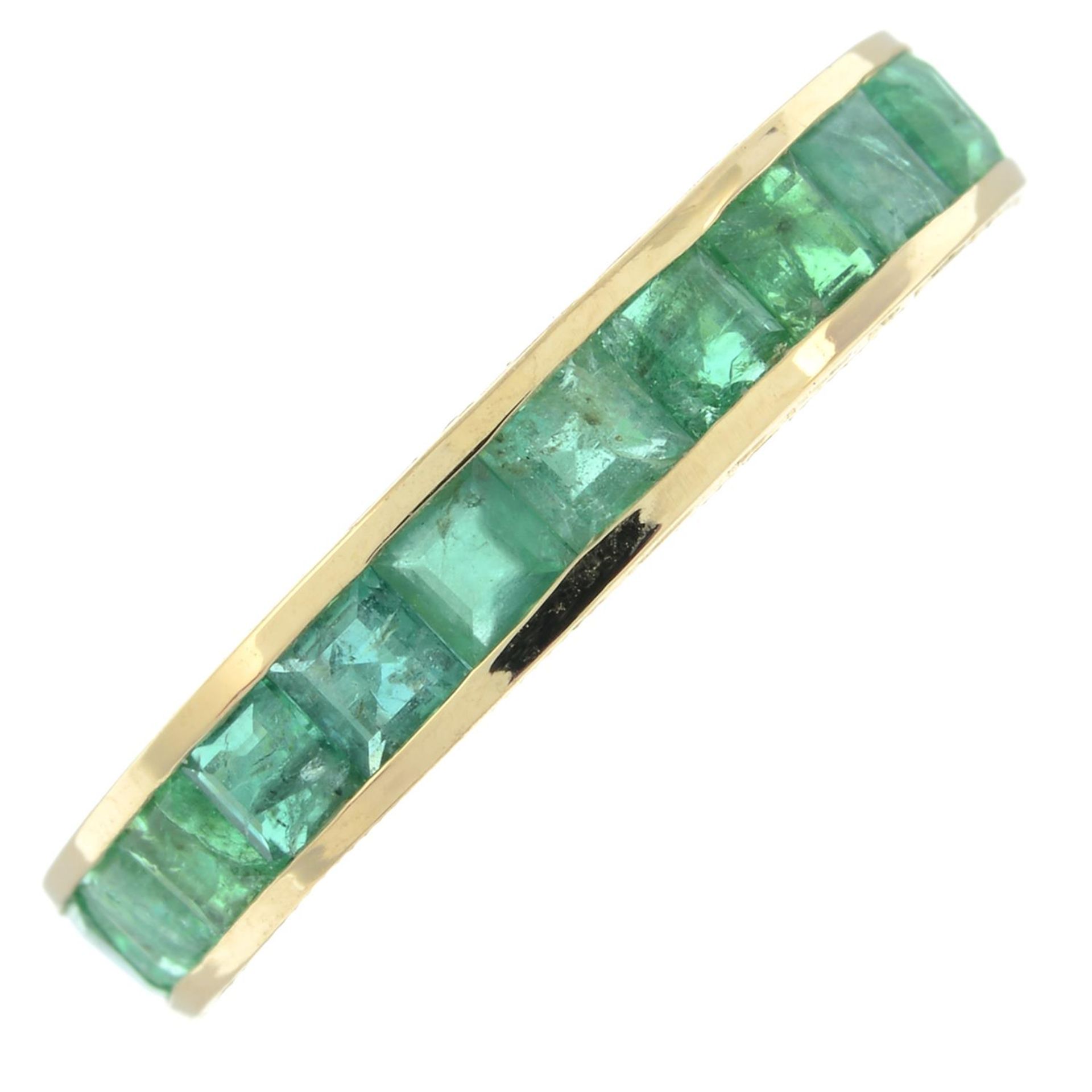 An emerald full eternity ring, with engraved sides.