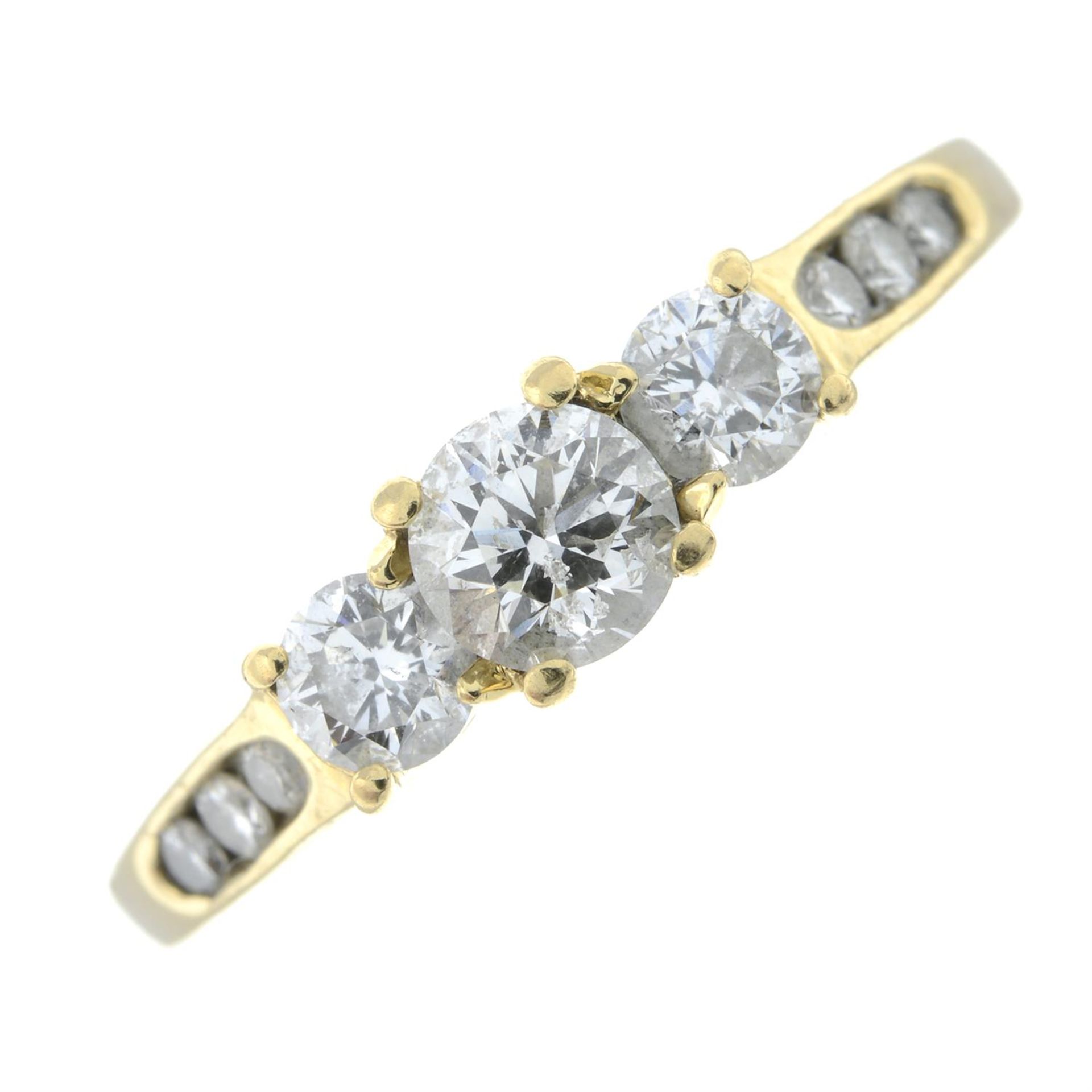 A brilliant-cut diamond three-stone ring, with diamond shoulders.