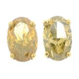 A pair of oval-shape 'brownish yellow' diamond stud earrings.