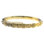 An early 20th century 15ct gold ornate floral motif hinged bangle.