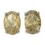 A pair of oval-shape Fancy Greenish Yellow diamond stud earrings.