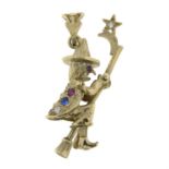 A 9ct gold cubic zirconia and vari-hue paste pendant, designed as a witch riding a broom stick.