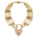 A gold fancy-link bracelet, with heart-shape padlock clasp.