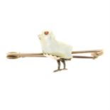 An early 20th century 9ct gold mother-of-pearl bird bar brooch, with garnet eye.