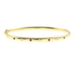 An 18ct gold ruby and diamond hinged bangle.