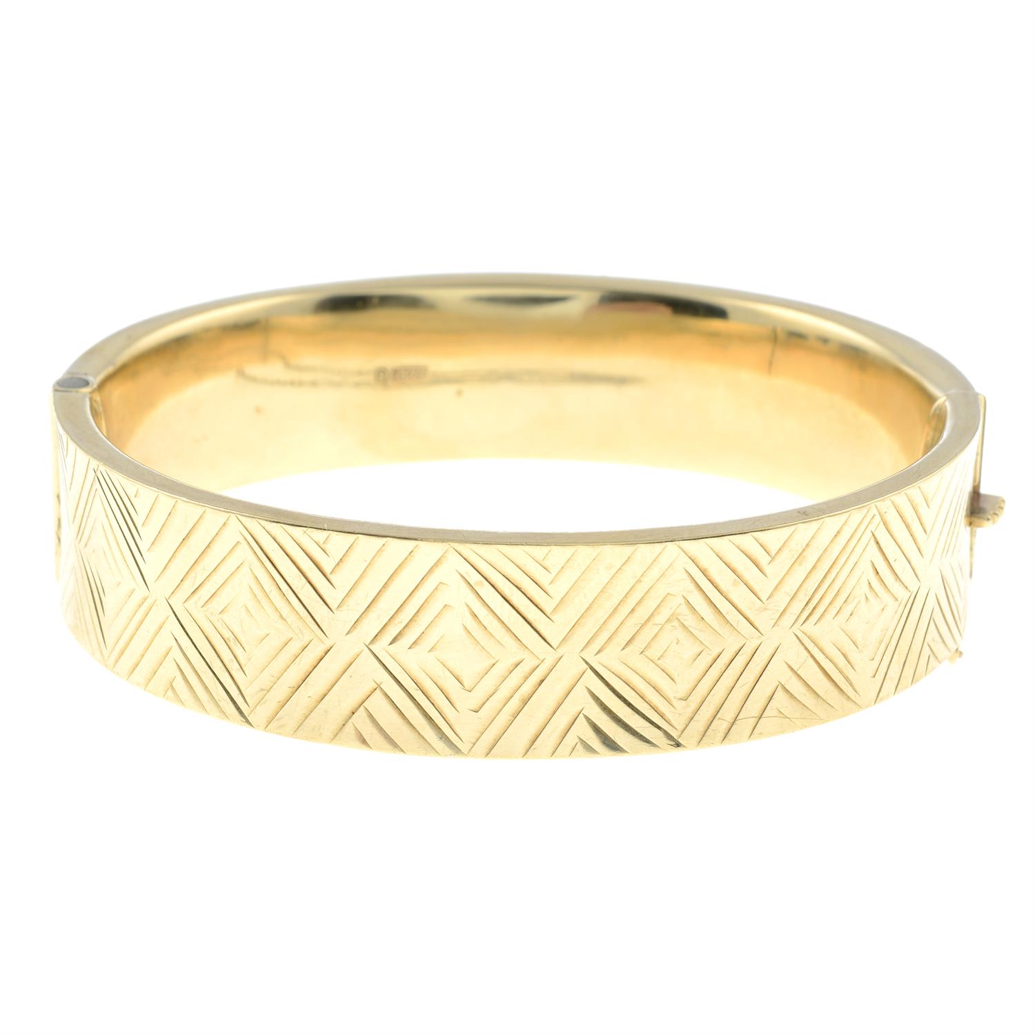 A 9ct gold hinged bangle, with cross motif.