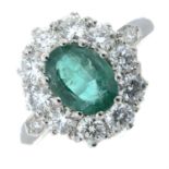 An emerald and diamond cluster ring.