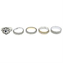 Five white metal rings, to include an 18ct gold textured band ring.